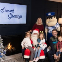 two sisters on Santa's lap with little brother on dad's lap